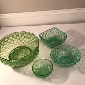 Large green bowl is plastic and 3 small bowls are glass